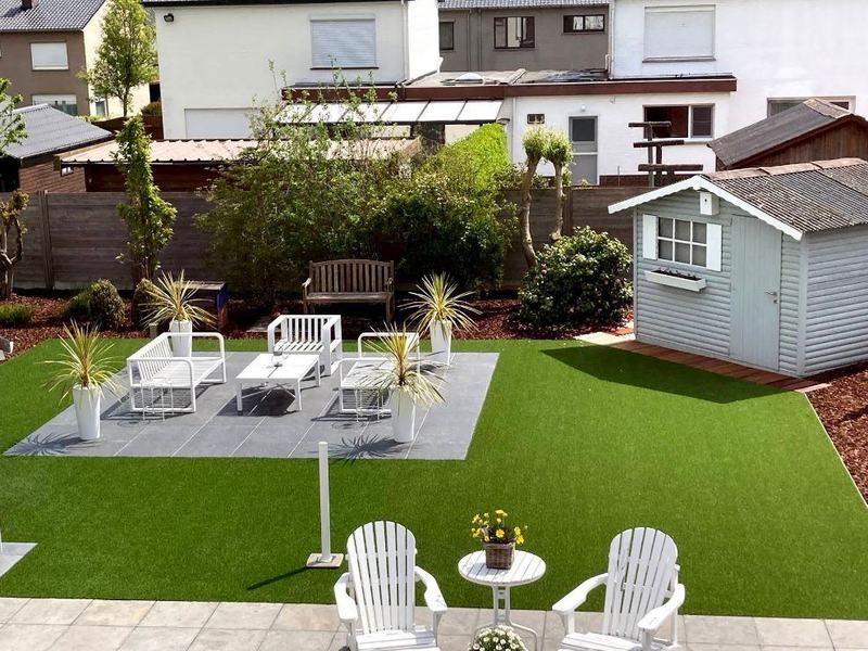 Tuin met kunstgras, aangelegd terras en tuinhuis